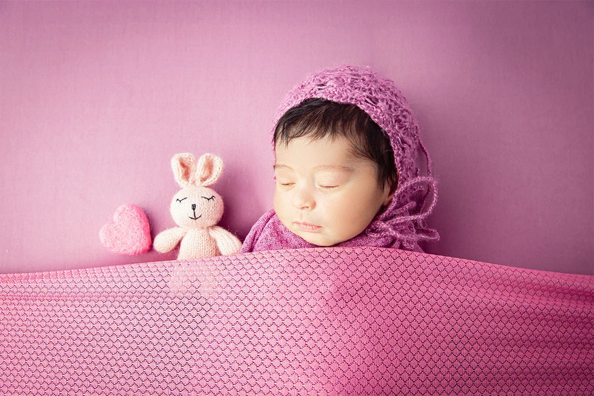 Newborn on a pink knit blanket