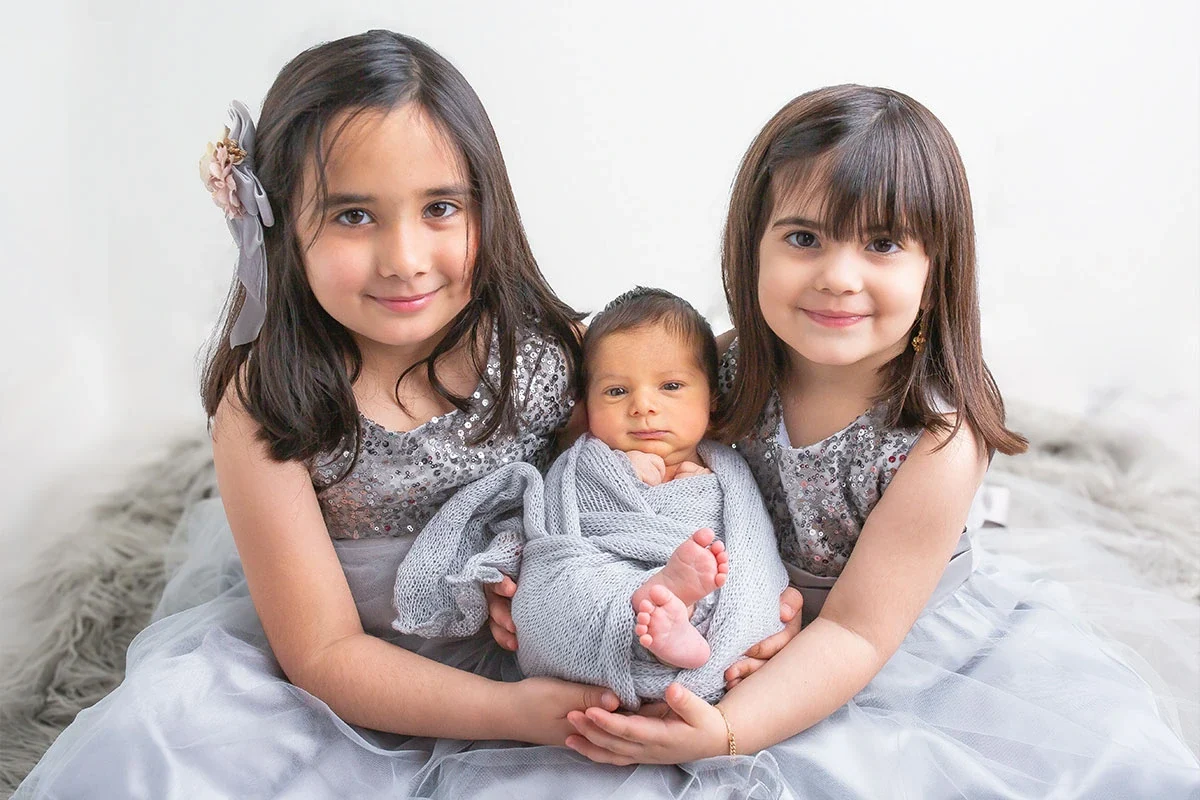 Family portrait with siblings and a newborn