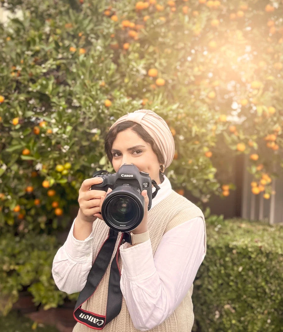 Marjan Allameh holding her camera outdoors